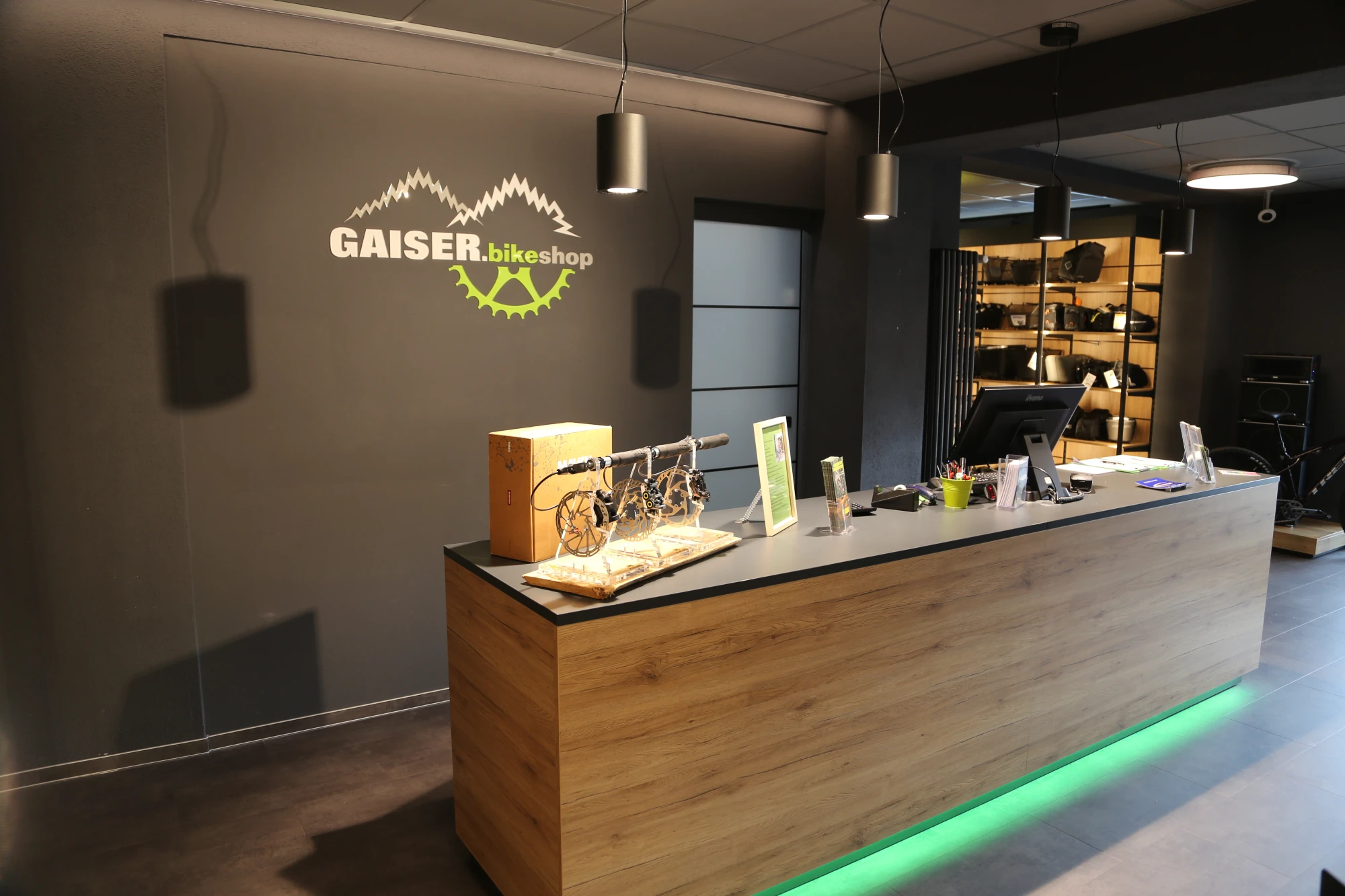 Person misst Rennrad in Fahrradladen mit mehreren Fahrr&auml;dern im Hintergrund.