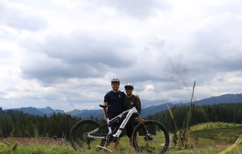 Person misst Fahrrad in Fahrradladen mit mehreren R&auml;dern im Hintergrund.