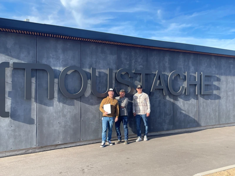 Zwei Mitarbeiter des Gaiser Bikeshop posieren mit einem Fahrrad vor dem Firmenlogo.