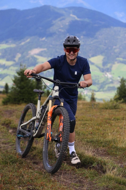 Junges Kind sitzt an einem B&uuml;roschreibtisch vor Computern in einem Bike-Shop-B&uuml;ro.
