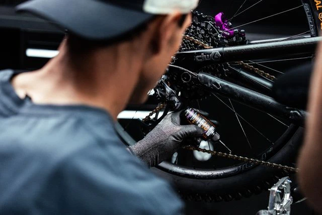Mechaniker arbeitet an Fahrradkette und Schaltwerk w&auml;hrend einer Reparatur.