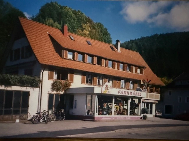 Gaiser Bikeshop Geb&auml;ude mit rotem Dach, Schaufenster und Fahrr&auml;dern davor.